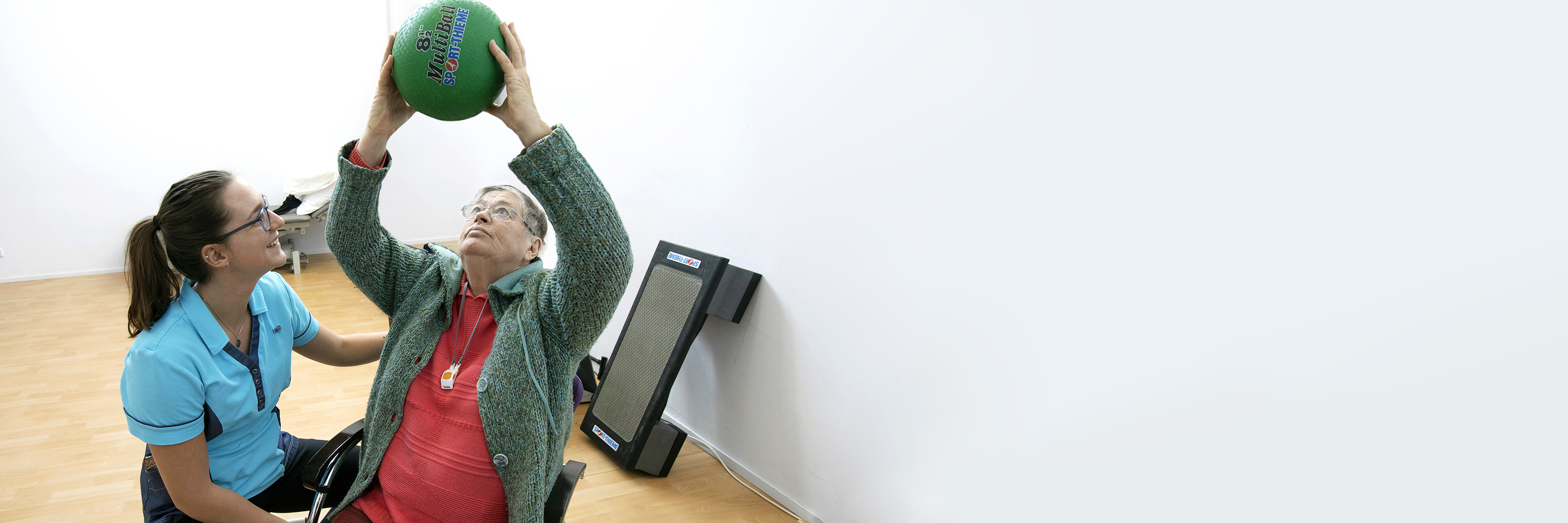 Fysiotherapeut en man doen oefening met bal